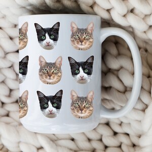May include: White ceramic mug with a repeating pattern of black and brown cat faces. The mug has a large handle.