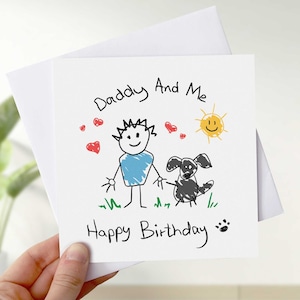 May include: A white card with a hand-drawn illustration of a person, a dog, and a sun. The text reads "Daddy And Me" and "Happy Birthday".