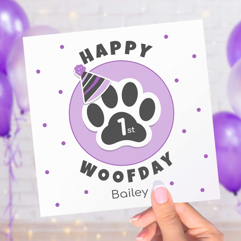 Puede incluir: Tarjeta de felicitaci&oacute;n cuadrada con las palabras "HAPPY WOOFDAY" y el nombre "Bailey". La tarjeta presenta una huella de pata con un gorro de fiesta y el n&uacute;mero "1st" dentro de un c&iacute;rculo lila, con lunares morados.