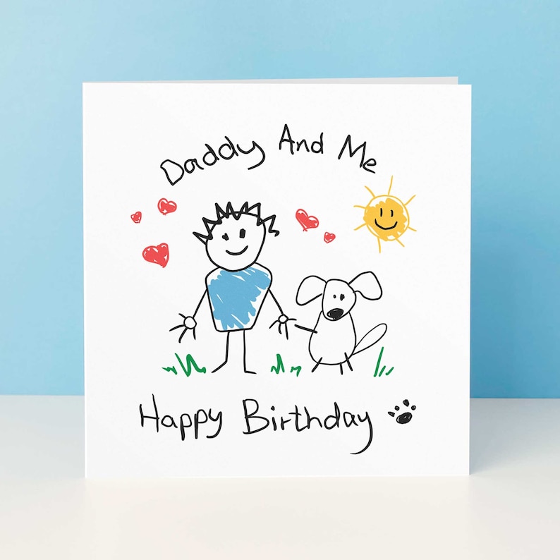 May include: A white card with a hand-drawn illustration of a person and a dog. The text reads "Daddy And Me Happy Birthday" with red hearts, a yellow sun, and green grass.
