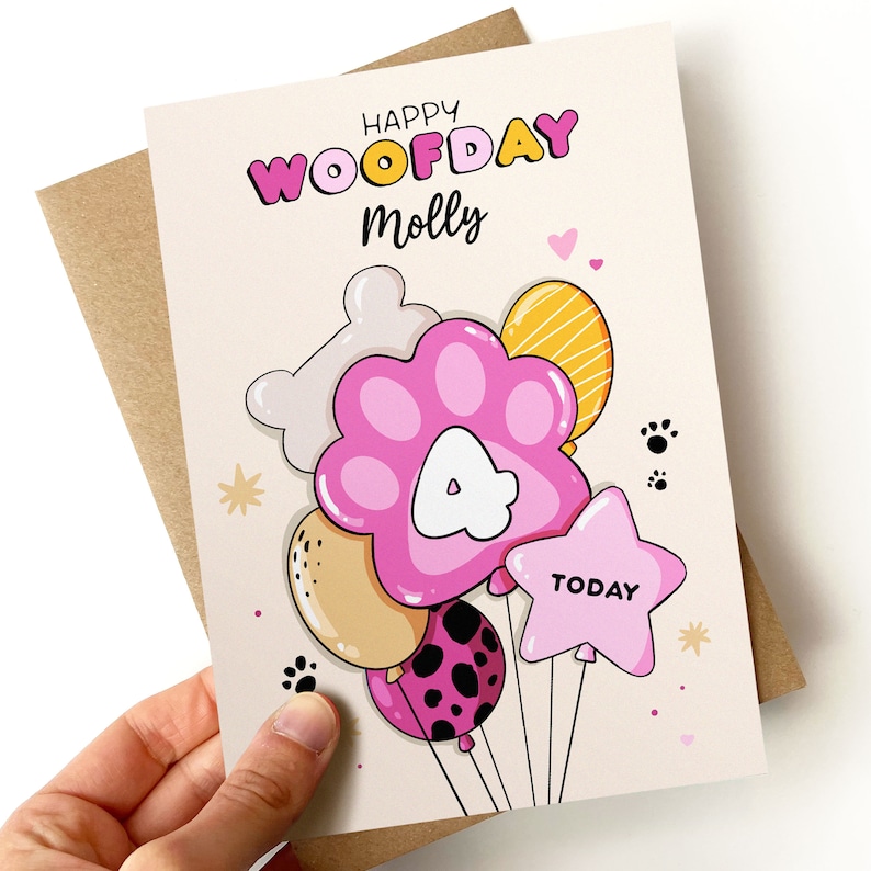 K&ouml;nnte beinhalten: Eine rosa und wei&szlig;e Geburtstagskarte mit dem Text "Happy Woofday Molly" und einem Pfotenballon mit der Nummer 4. Die Karte hat ein rosa, gelbes und wei&szlig;es Ballon-Thema mit Pfotenabdr&uuml;cken und Sternen.