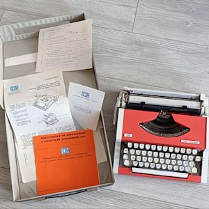 UNIS tbm (OLYMPIA Traveller De Luxe), una máquina de escribir portátil vintage de la década de 1970, en excelentes condiciones, con estuche y documentos. En estado nuevo.