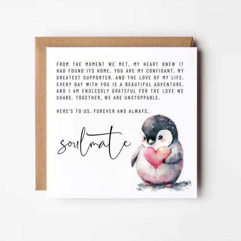 May include: A white card with a black and white illustration of a penguin holding a red heart. The card has a message that reads "From the moment we met, my heart knew it had found its home. You are my confidant, my greatest supporter, and the love of my life. Every day with you is a beautiful adventure, and I am endlessly grateful for the love we share. Together, we are unstoppable. Here's to us, forever and always. Soulmate."
