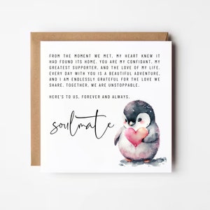 May include: A white card with a black and white penguin illustration holding a red heart. The card has a message that reads "From the moment we met, my heart knew it had found its home. You are my confidant, my greatest supporter, and the love of my life. Every day with you is a beautiful adventure, and I am endlessly grateful for the love we share. Together, we are unstoppable. Here's to us, forever and always. Soulmate"