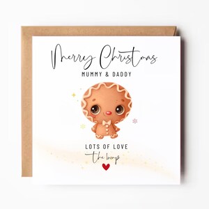 May include: A Christmas card with a brown kraft paper border. The white card features a gingerbread man illustration and the text "Merry Christmas Mummy & Daddy, Lots of Love, the bump" with a red heart.