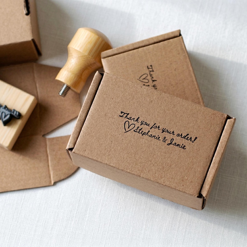Custom thank you stamp on small kraft mailer boxes with handwritten script impression for Etsy seller and small business order packaging