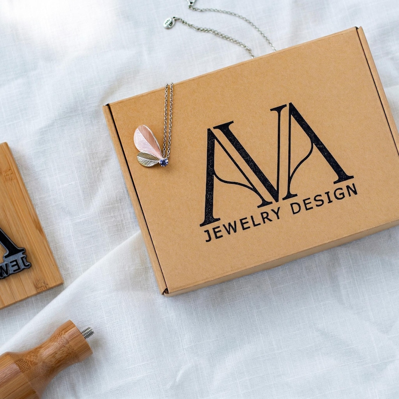 Custom logo rubber stamp made of wood on kraft mailer box with sharp monogram impression for jewelry brand and boutique business packaging