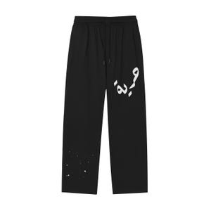 May include: Black sweatpants with a drawstring waist and a wide leg. The pants feature white Arabic script on the left leg and white paint splatter near the bottom. A casual, comfortable style.
