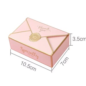 May include: Pink envelope-shaped gift box with gold accents. The box is 10.5 inches long, 7 inches wide, and 3.5 inches tall. The box has the text "Thank You" and "Specially for you" printed on it.