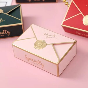 May include: Pink envelope-shaped gift box with gold trim and a gold wax seal. The box has the text "Thank you" and "Specially for you" printed on it.