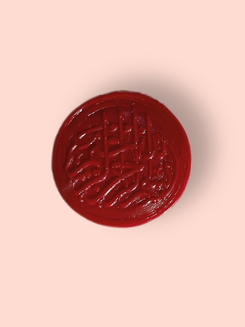 May include: A red wax seal with a decorative design. The seal is round and has a raised design.