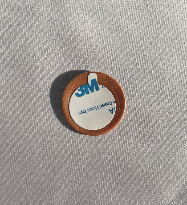 May include: A round, copper-colored adhesive sticker with a white label that reads "3M  94  e Coated Tissue Tape".