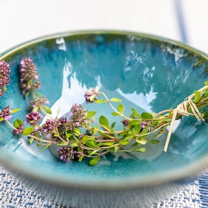 Può includere: Un mazzo di timo fresco con fiori viola in una ciotola di ceramica turchese.