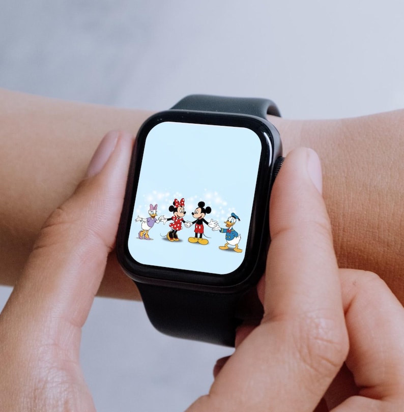 Puede incluir: Un reloj inteligente negro con un fondo blanco que muestra una imagen de dibujos animados de Mickey Mouse, Minnie Mouse, Donald Duck y Daisy Duck. Los personajes sonr&iacute;en y se toman de la mano.