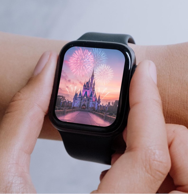 May include: A black smartwatch with a digital display showing a picture of Cinderella's Castle at Walt Disney World with fireworks in the sky.