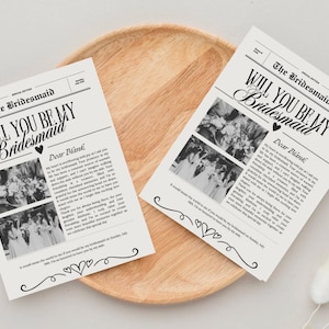 以下が含まれることがあります： 「The Bridesmaid」と「Will You Be My Bridesmaid?」の文字とハート、手書きのメッセージが書かれた、白黒の新聞風カード。カードには白黒の人々の写真が掲載されている。