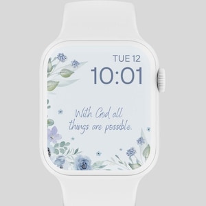 Pode incluir: Smartwatch branco com um design floral na tela. A tela exibe a hora, a data e o texto "With God all things are possible." O design floral apresenta flores azuis e roxas e folhas verdes.