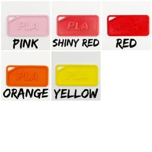May include: A selection of rectangular PLA tags in shades of pink, shiny red, red, orange, and yellow. Each tag features a small corner hole and the embossed letters "PLA". The colours are labelled with bold, black text.