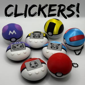 May include: A selection of spherical clickers in various colours, each with distinct designs and character emblems. The clickers feature colours such as red, blue, yellow, and purple. The text "CLICKERS!" is displayed above the clickers.
