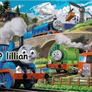 May include: A blue and red toy train engine with the name "@lillian" on the side, next to a green toy train engine. Both engines are on a track with a bridge in the background.