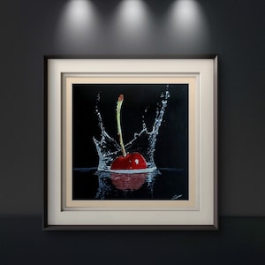 Può includere: Una ciliegia rossa con un gambo verde cade in una ciotola d'acqua, creando uno schizzo di goccioline d'acqua.
