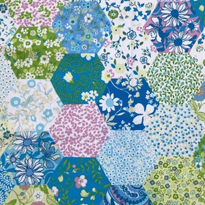 May include: A patchwork fabric with a hexagonal pattern in shades of blue, green, and pink. The fabric features a variety of floral designs.