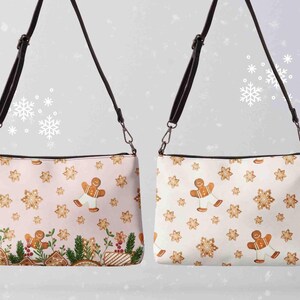 Könnte beinhalten: Zwei Umhängetaschen mit festlichem Lebkuchen-Thema. Eine Tasche hat einen hellrosa Hintergrund, die andere ist weiß. Beide Taschen zeigen Lebkuchenmänner und Schneeflockenmuster mit schwarzen Riemen und silberfarbenen Beschlägen.