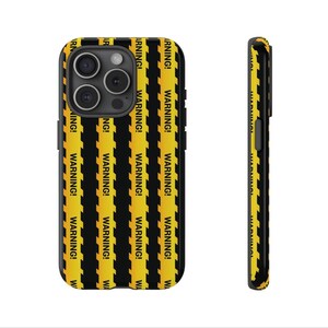 May include: A black phone case with a yellow and black warning tape design. The case has a raised camera bump and a black border.