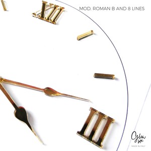 May include: Close-up of a white clock face with gold-colored Roman numerals and hands. The clock face has the text "MOD. ROMAN B AND 8 LINES". The clock hands are positioned at approximately 10:15.