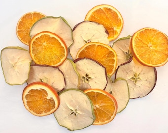 May include: A collection of dehydrated fruit slices consisting of bright orange citrus rounds and pale, dried apple rings with visible centers, arranged in a cluster to showcase their varied textures and natural colors.