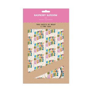 May include: A package of wrapping paper and gift tags with a colorful pattern of the words "Happiest Birthday Wishes" on a cream background. The package is pink and brown and has the text "Raspberry Blossom for Penny Kennedy" on the front.