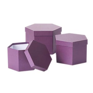 May include: Three purple hexagonal gift boxes made of sturdy cardboard. One box is open with its lid resting beside it, revealing a white interior, while the other two boxes remain closed with their matching purple lids securely in place.