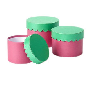 Juego de 3 sombrereras redondas festoneadas con tapa en contraste, base rosa, tapa verde vivo y maceta de diseño. Ecológicas.