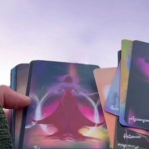 K&ouml;nnte beinhalten: Ein Deck Orakelkarten mit farbenfrohen, abstrakten Designs. Die Karten zeigen Bilder von Figuren und Symbolen, und der Text "Aufstieg", "Geduld" und "Liebe" ist auf den Karten sichtbar.