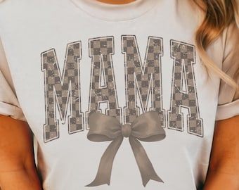 May include: White t-shirt with a brown checkered "MAMA" graphic and a brown bow.