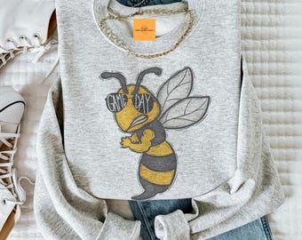 May include: Gray sweatshirt with a cartoon bee wearing sunglasses and the text "Game Day".