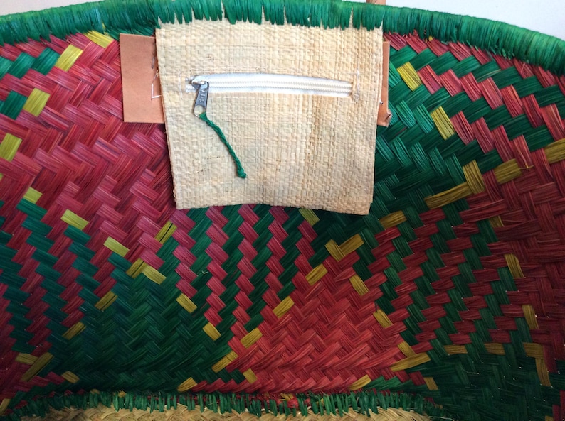 May include: A woven basket with a red, green, and yellow pattern. The basket has a zippered pocket on the front.