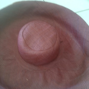 Puede incluir: Un sombrero grande, redondo y marr&oacute;n hecho de material tejido. El sombrero tiene un ala ancha y una corona poco profunda.