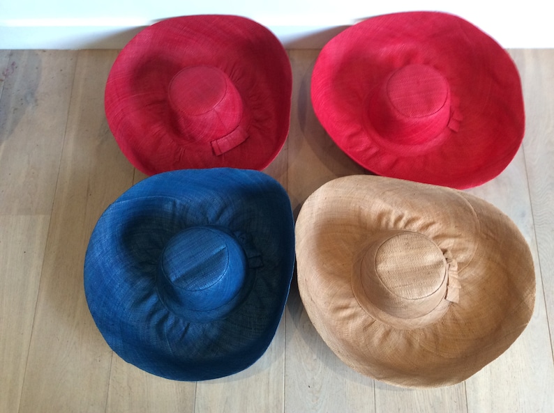 Puede incluir: Cuatro sombreros de sol de ala ancha en diferentes colores: rojo, azul, marr&oacute;n y beige. Los sombreros est&aacute;n hechos de un material tejido y tienen un ala ancha que proporciona sombra del sol.