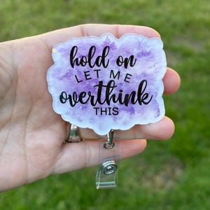 May include: A white acrylic badge holder with a purple watercolor design and the text "hold on let me overthink this".