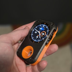 May include: A black and orange smartwatch with a digital display showing the time and weather. The watch has a rugged design with a circular screen and an orange band. The watch is held in a hand.
