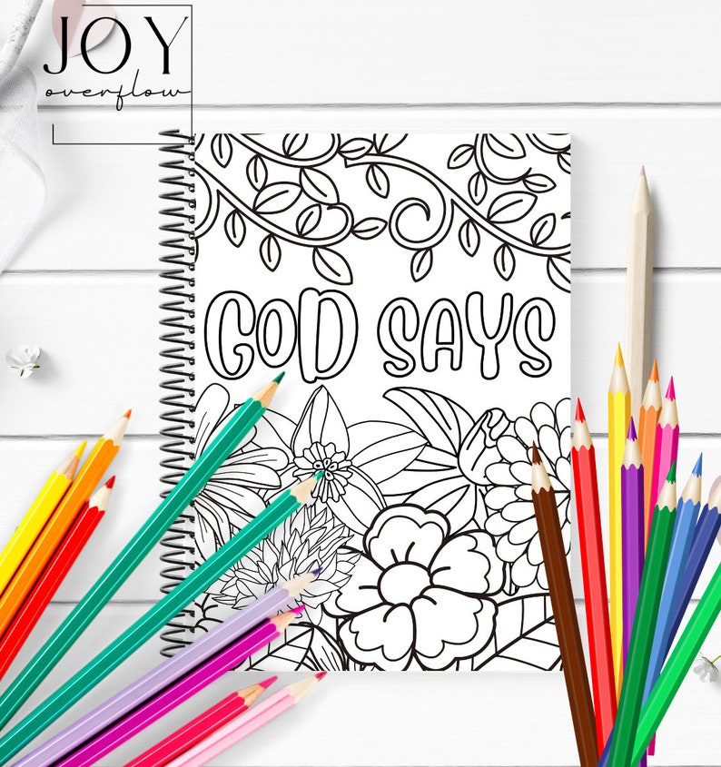 K&ouml;nnte beinhalten: Ein Schwarzwei&szlig;-Malbuch mit Spiralbindung. Der Umschlag zeigt ein florales Design mit dem Text "GOD SAYS" in einer fetten, stilisierten Schrift.