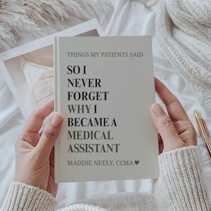 Può includere: Un taccuino color crema con il testo "THINGS MY PATIENTS SAID" e il messaggio "SO I NEVER FORGET WHY I BECAME A MEDICAL ASSISTANT." Il nome dell'autore, Maddie Neely, CCMA, è stampato sulla copertina. Una penna d'oro è appoggiata vicino.