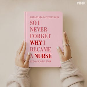 May include: A pink notebook with the text "THINGS MY PATIENTS SAID" and "SO I NEVER FORGET WHY I BECAME A NURSE." The notebook is held by hands and has the name "REAGAN, BSN, RN" at the bottom. The word "PINK" is in the top right corner.