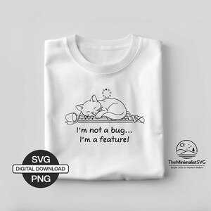 Puede incluir: Camiseta blanca con un dibujo lineal negro de un gato durmiendo sobre un teclado, una taza de café derramada y el texto "I'm not a bug... I'm a feature!". Incluye el texto "SVG DIGITAL DOWNLOAD PNG" y un logotipo de TheMinimalistSVG.