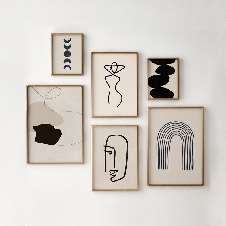 May include: Set of six minimalist abstract art prints in black and white with gold frames. The prints feature a woman's figure, a face, a rainbow, a moon phase, and two abstract shapes.