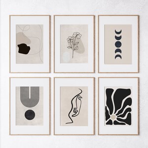 May include: Six minimalist art prints in wooden frames, each featuring a different abstract design in black and white on a beige background. The designs include a flower, a crescent moon, a geometric shape, a face, and a sun.