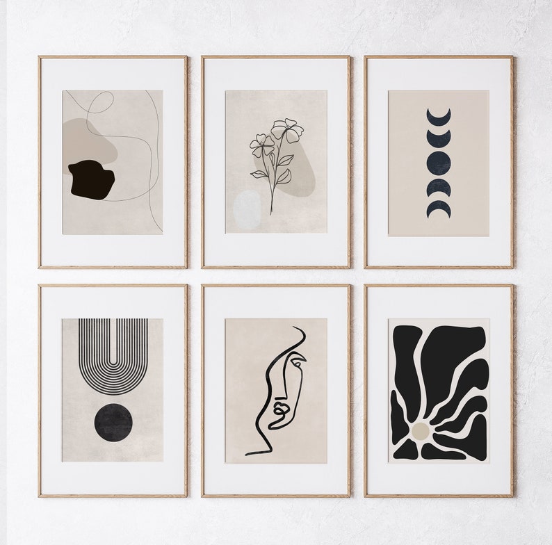 May include: Six minimalist art prints in wooden frames, each featuring a different abstract design in black and white on a beige background. The designs include a flower, a crescent moon, a geometric shape, a face, and a sun.