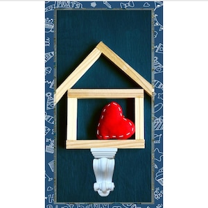May include: A wooden house-shaped frame with a red heart inside, set against a dark blue background. The frame is supported by a white decorative column. The word "PARTY" is at the top and "Birthday" at the bottom.
