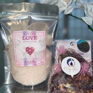 May include: Two bags of bath salts, one with a pink label that says "Divine Love Invocation" and "Ritual Bath Salt" and the other with a pink label that says "Empathic Moon".